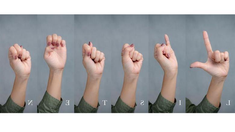 Hands gesturing using sign language to spell the word “listen”.